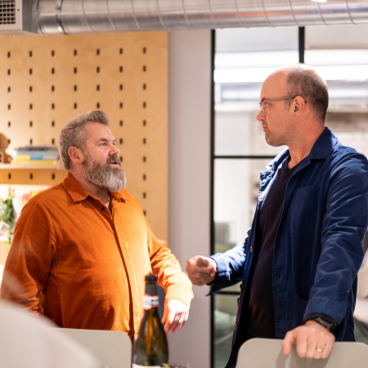 Two men engage in a conversation in a modern educational space, highlighting the future of collaborative learning environments.