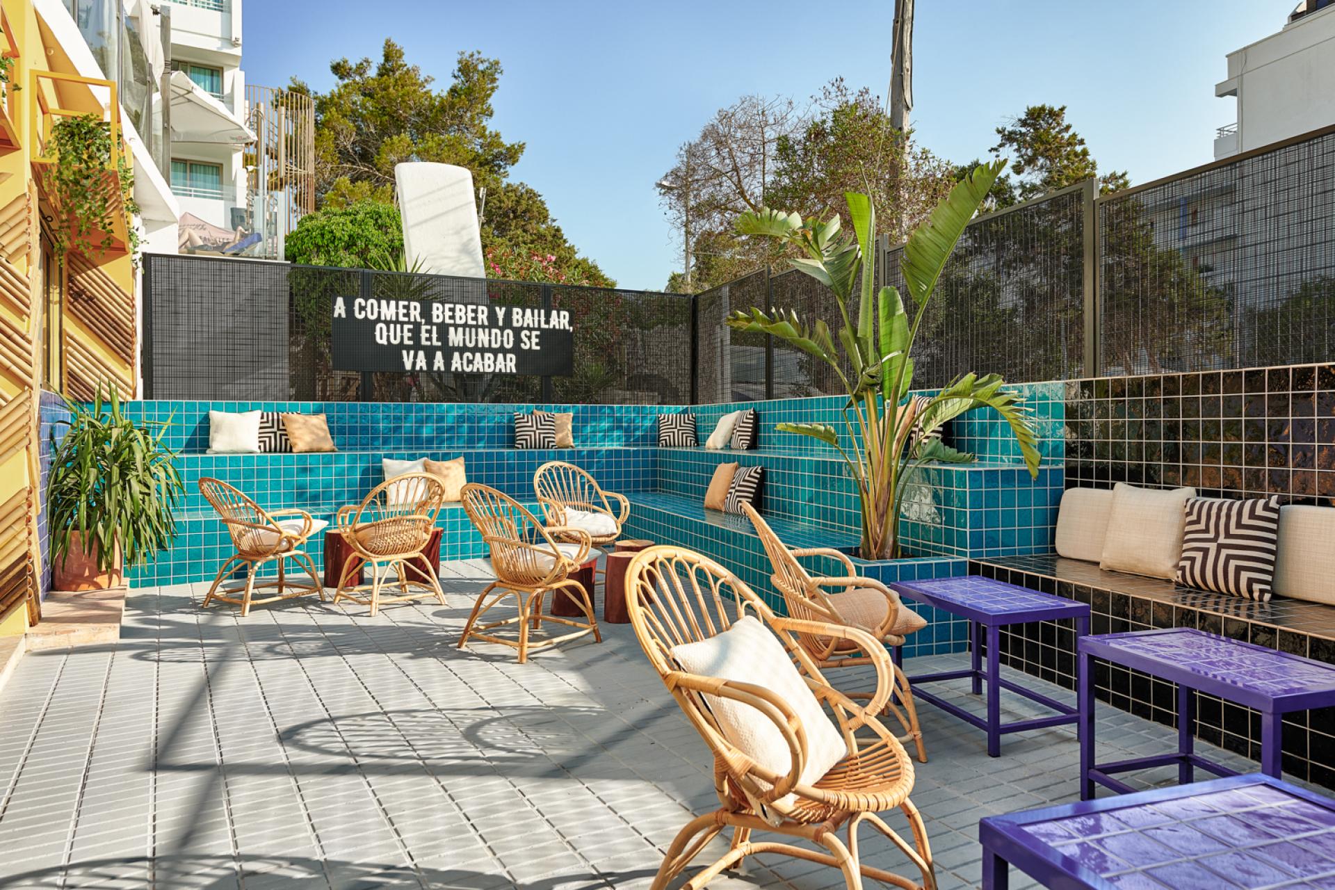 Stylish outdoor seating area at Bar TORÖ in Ibiza, featuring vibrant tile work and tropical plants.