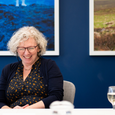 Smiling woman at a modern workplace meeting, representing collaboration and the human aspect of technology integration.