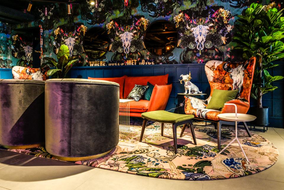 Vibrant lounge area at Manchester's Qbic hotel featuring bold furniture, unique artwork, and lush greenery by BOBO1325.