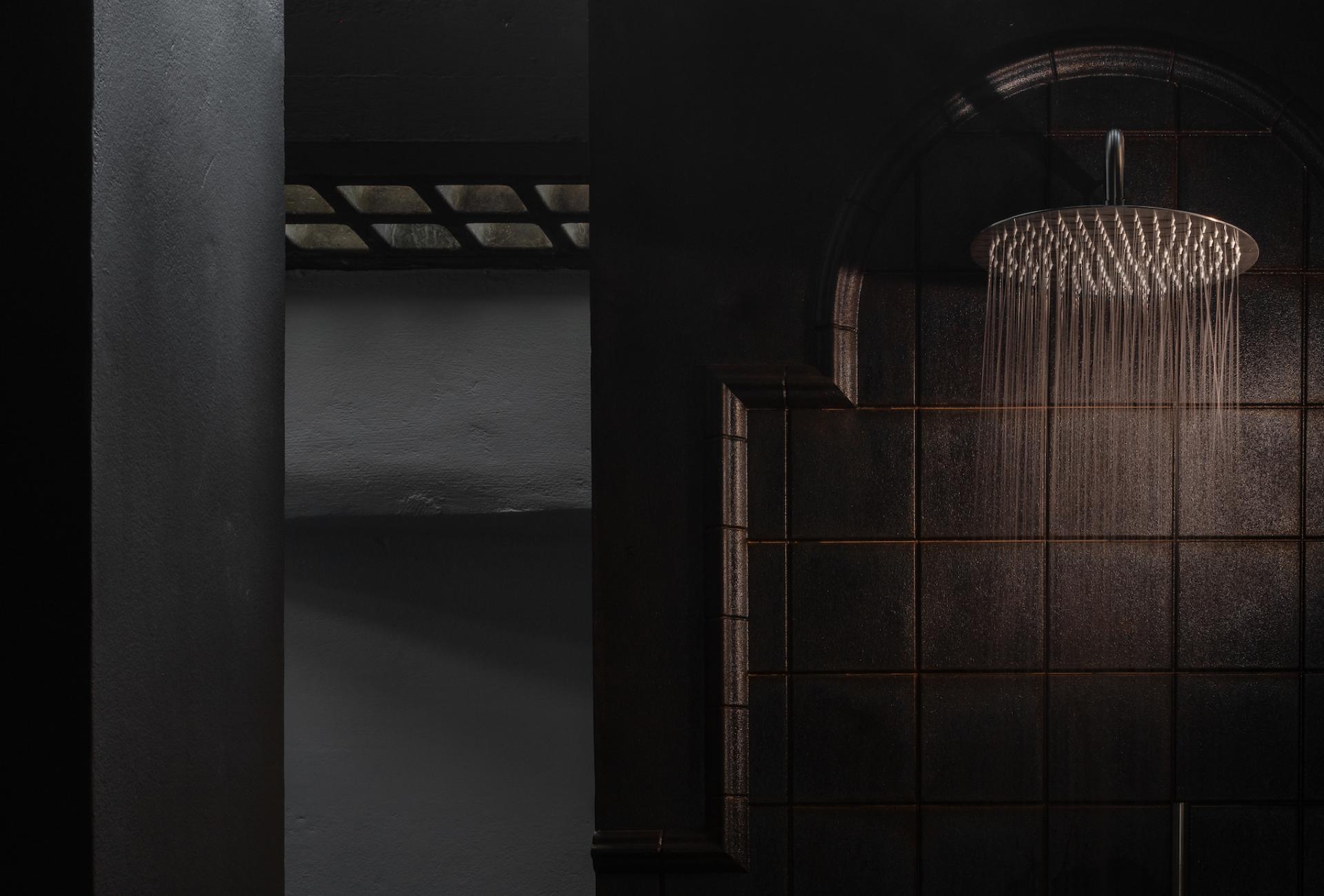 Stylish bathroom featuring a modern rain showerhead with a sleek tile backdrop, enhancing the new showroom experience.
