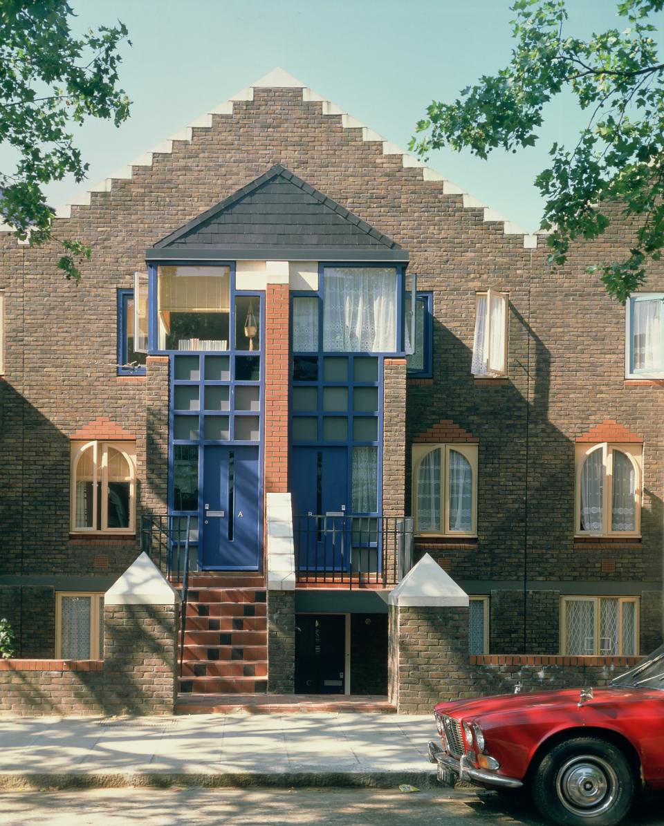 Modern British architecture featuring a unique brick facade, distinctive blue doors, and geometric design elements.