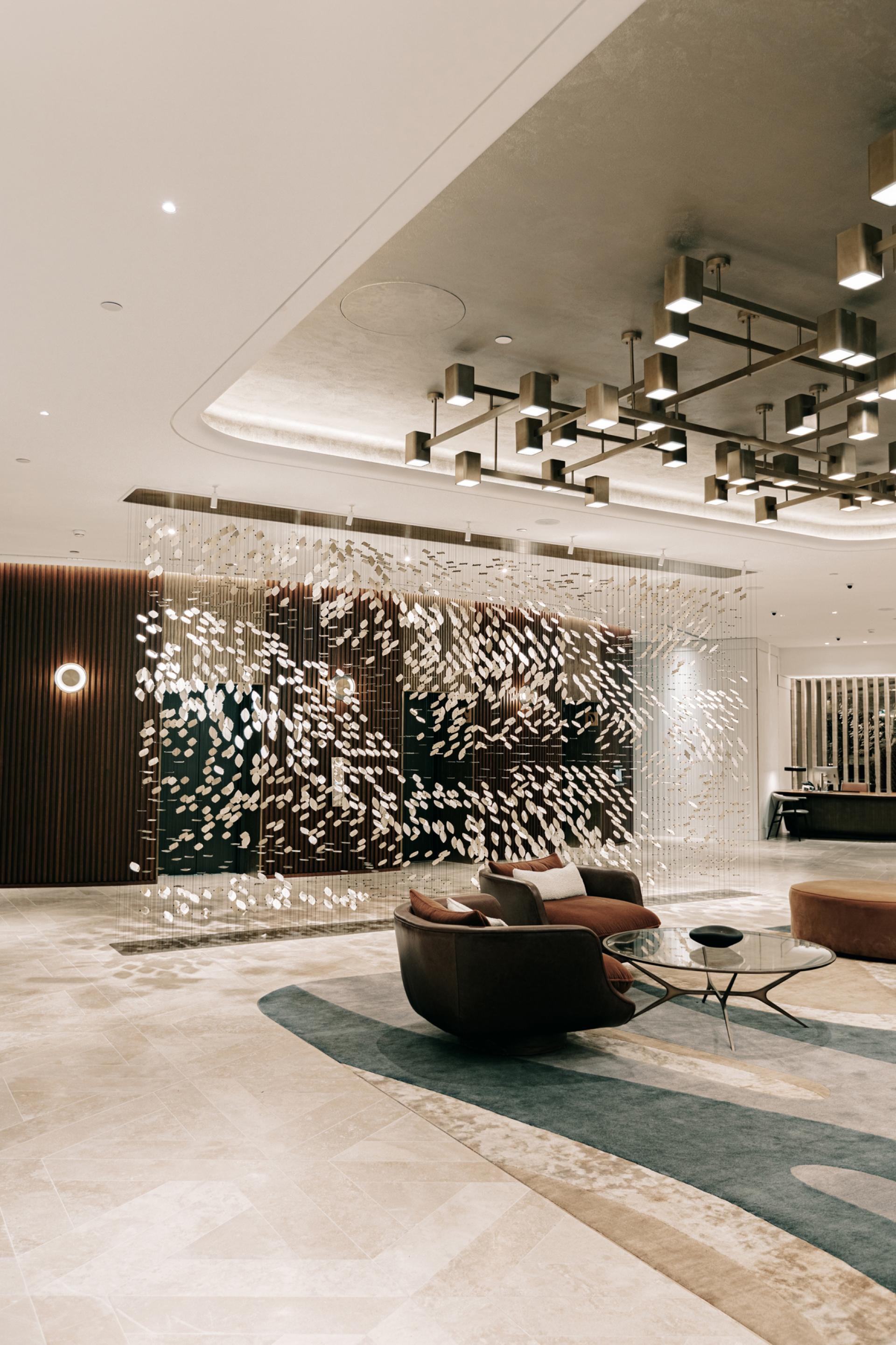 Elegant interior with abstract fish-scale partition, contemporary furniture, and stylish lighting, showcasing Giles Miller Studio's design innovation.