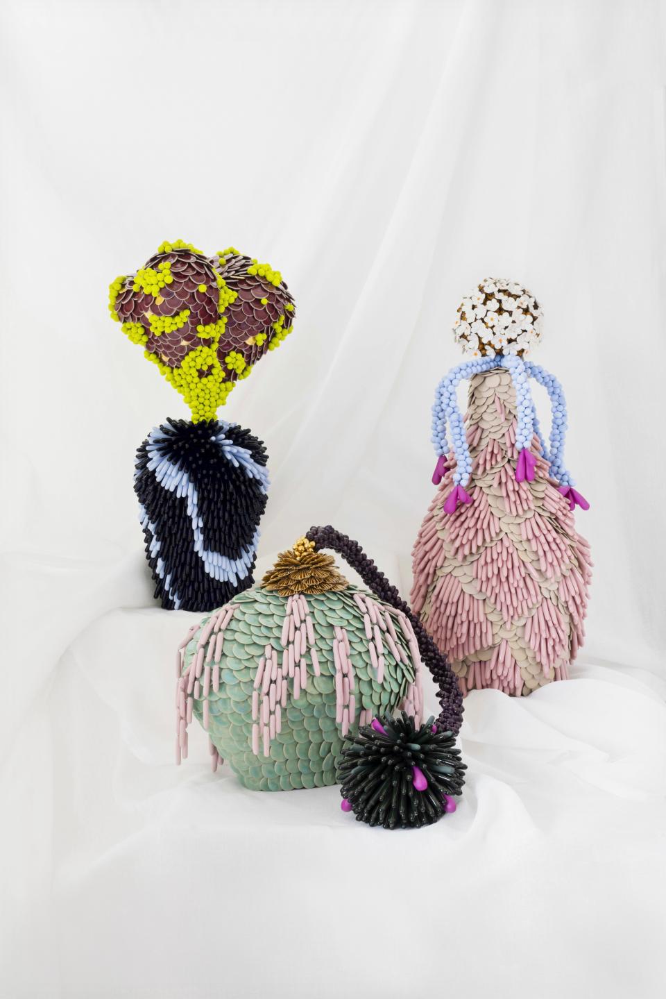 Colorful handmade ceramic sculptures resembling abstract vases, featuring intricate patterns, displayed at London Craft Week 2024.