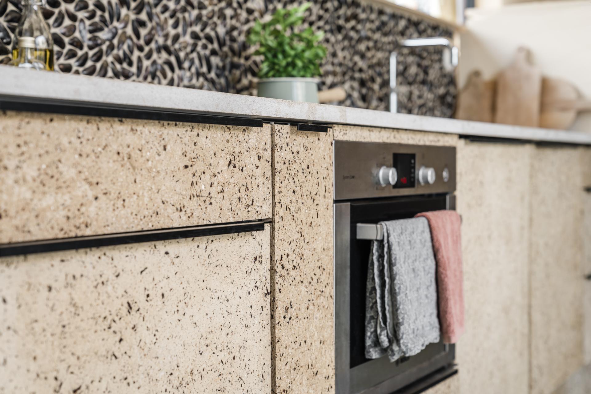 Kitchen featuring sustainable biomaterials with speckled light-colored cabinetry and an embedded oven, promoting low-carbon design.