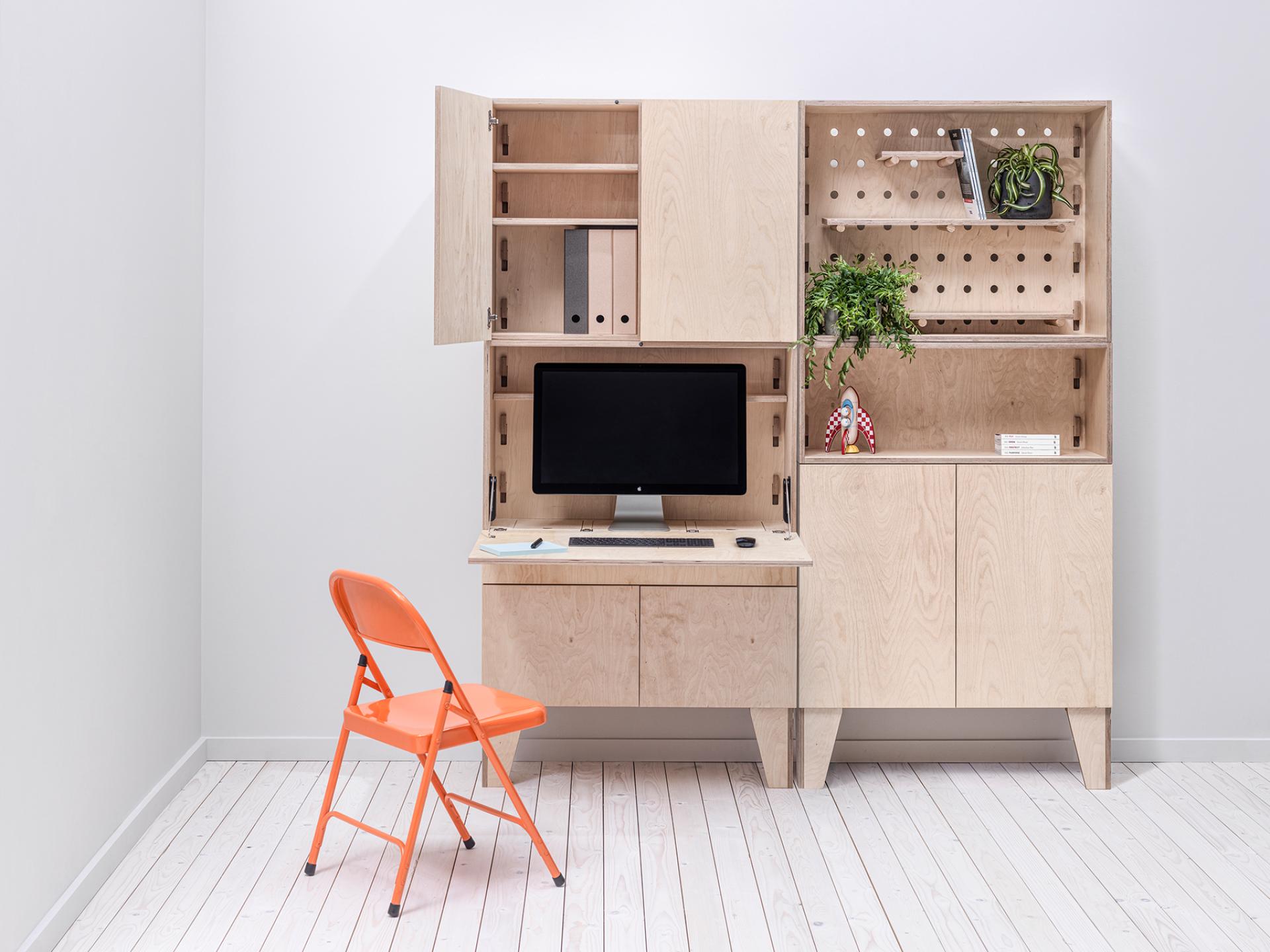 Bespoke modular workspace by Arnie.M featuring a wooden desk, monitor, and orange chair, crafted in Manchester.