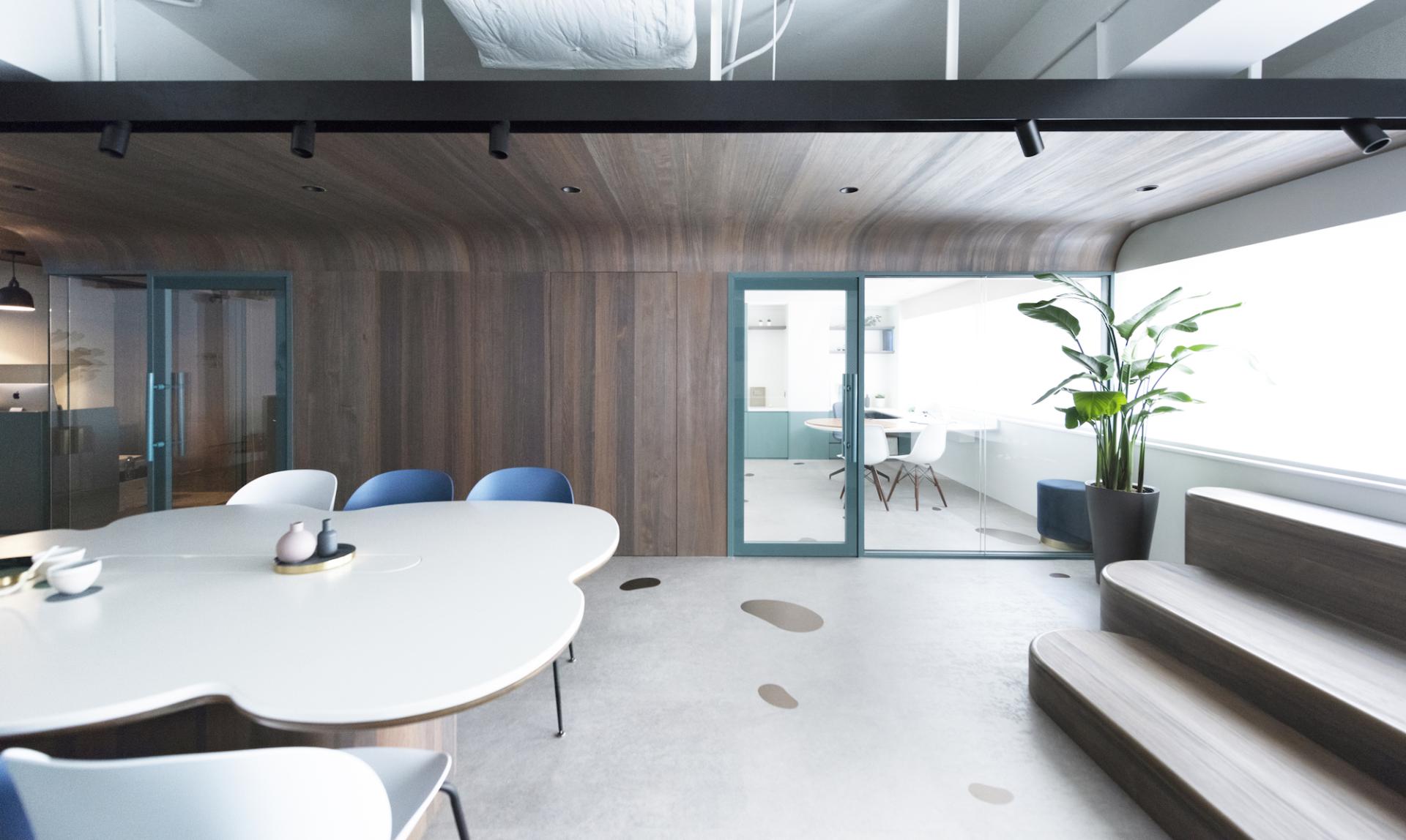 Modern paediatric clinic interior featuring a welcoming playscape design with curved wooden ceilings and vibrant furnishings.