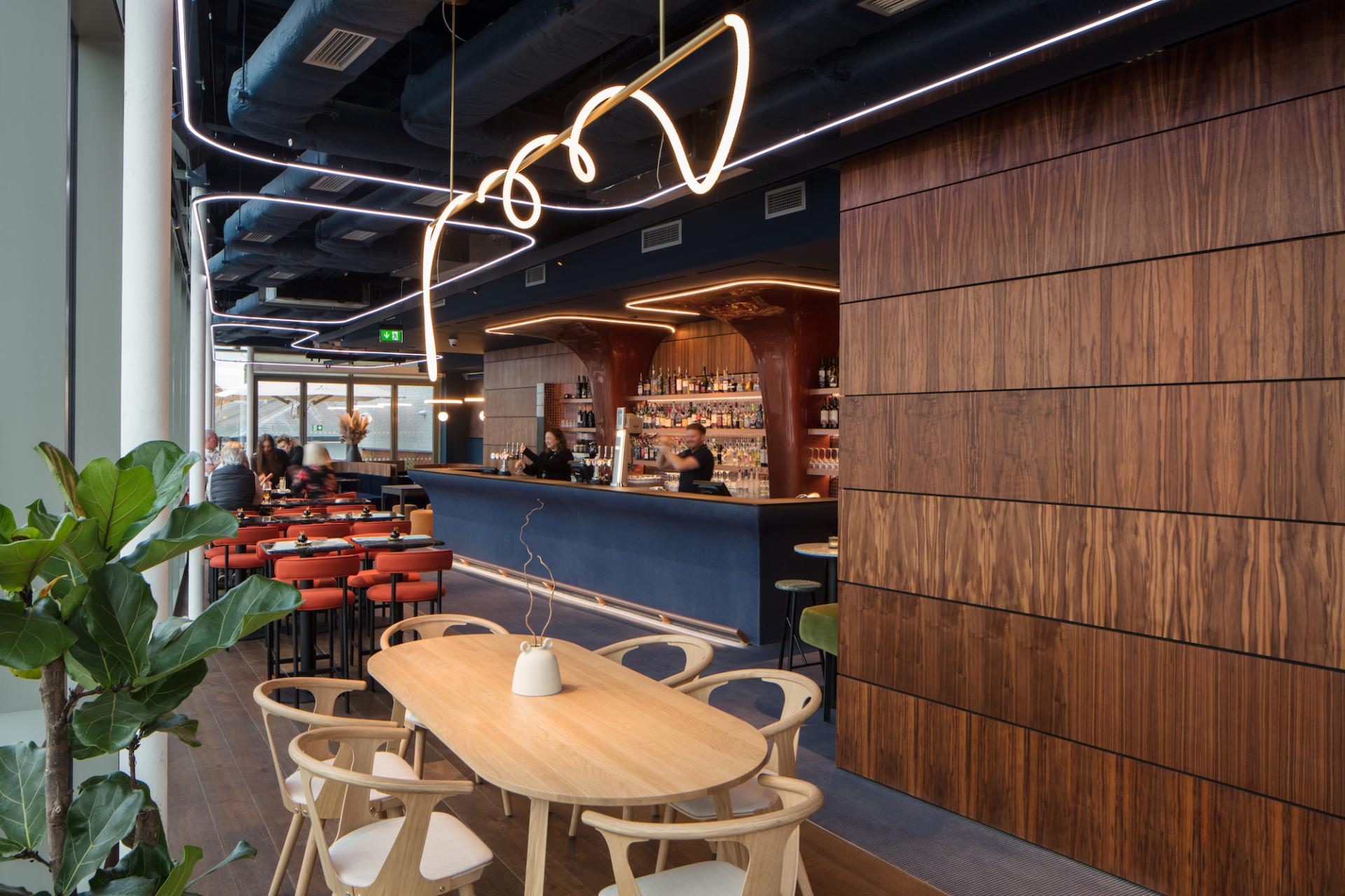 Stylish interior of M'Arks Sky Bar featuring a modern bar, cozy seating, and vibrant decor in London.