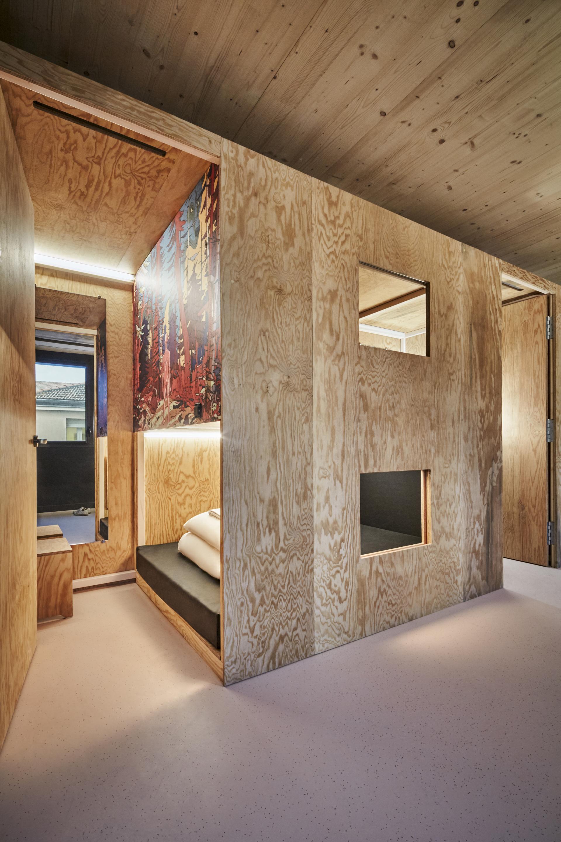 Modern interior of a JO&JOE Paris Gentilly room featuring wooden walls, artistic accents, and cozy seating area.