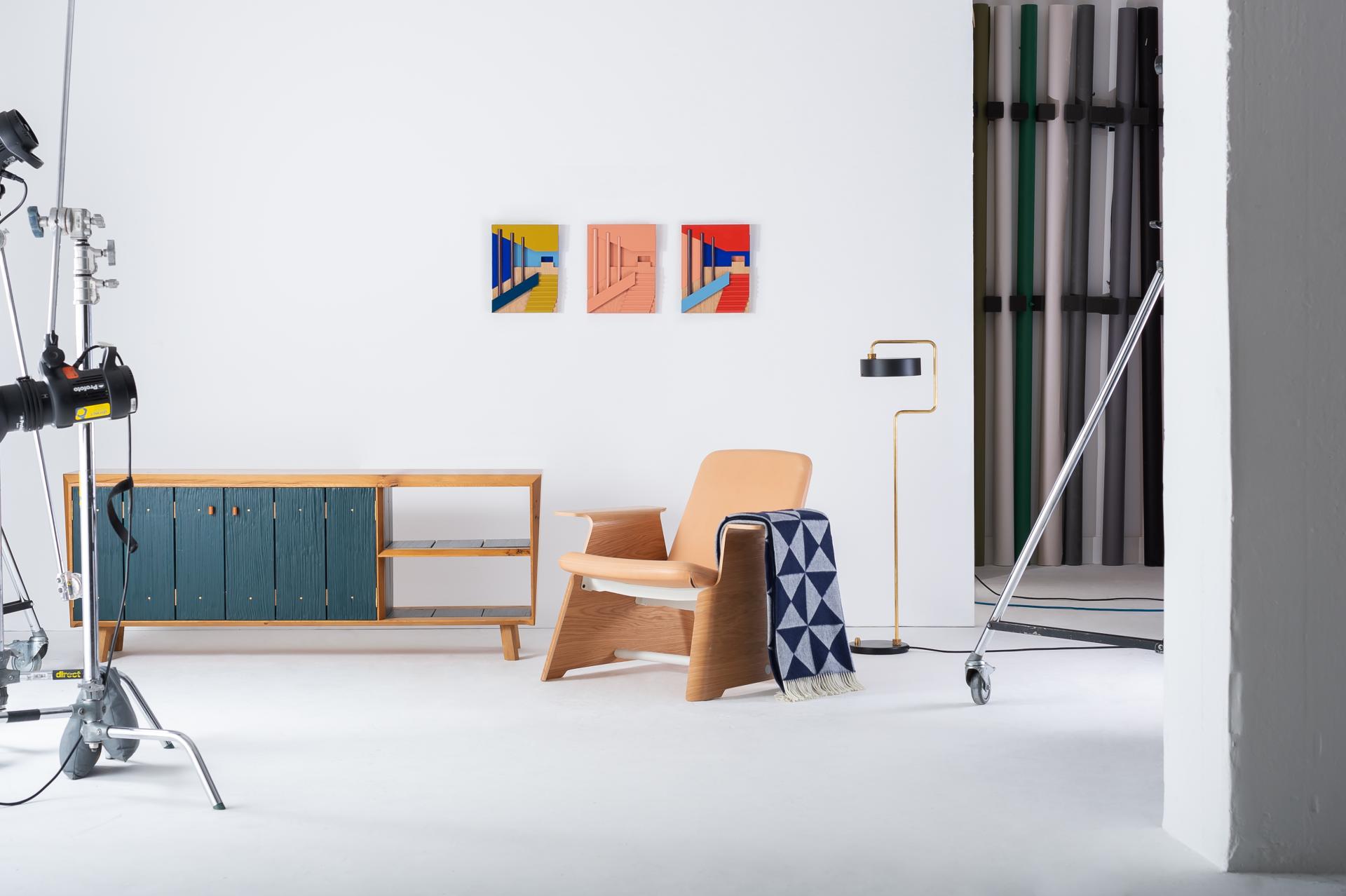 Stylish interior scene featuring a modern chair, decorative items, and colorful artwork, highlighting designjunction's theme of (Re)act.