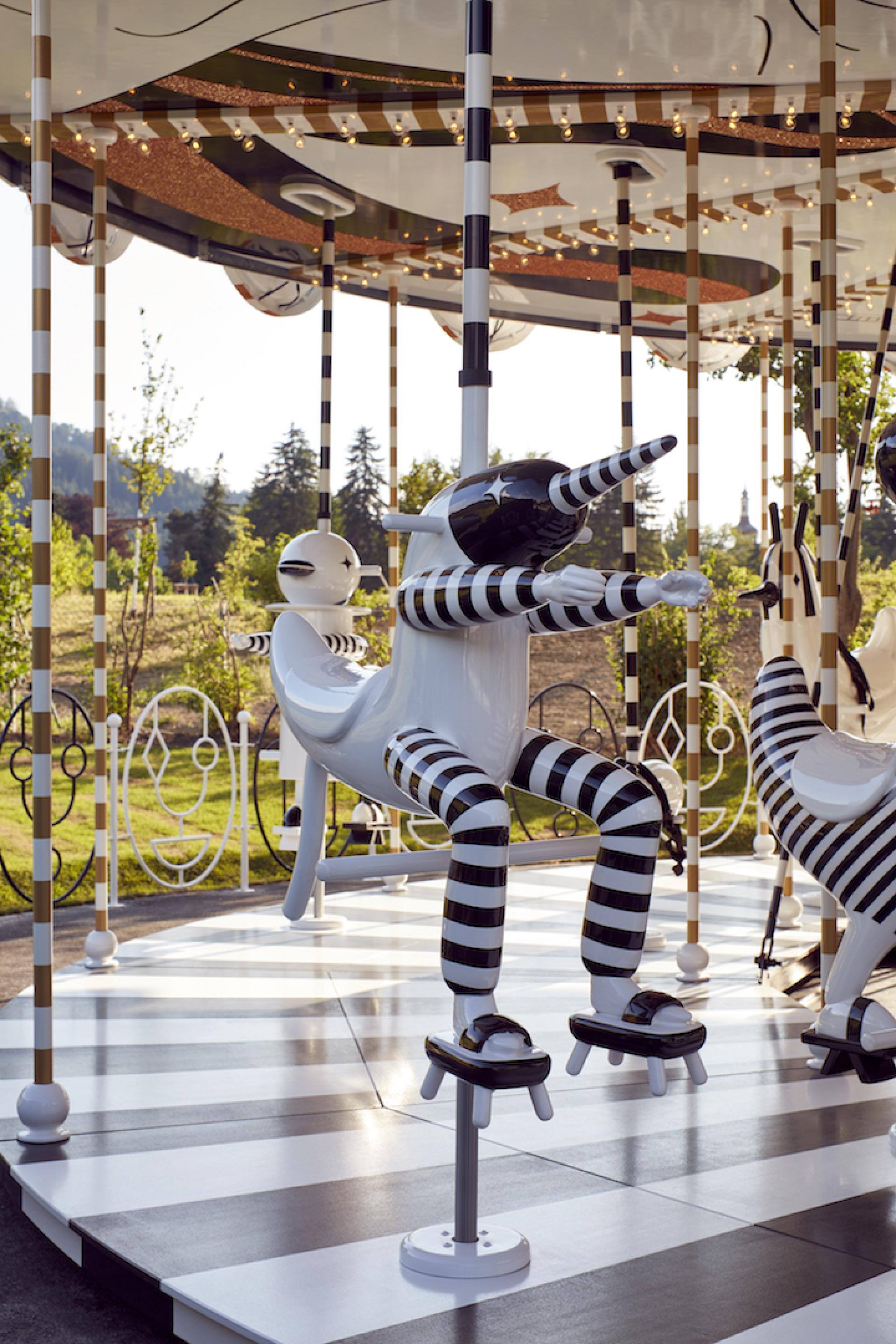 Colorful stylized carousel figures designed by Jaime Hayon, showcasing artistic creativity and joy in motion.