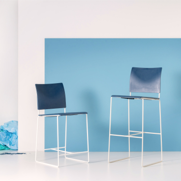 Sustainable blue Finn stools made from repurposed hospital waste, set against a light blue backdrop.
