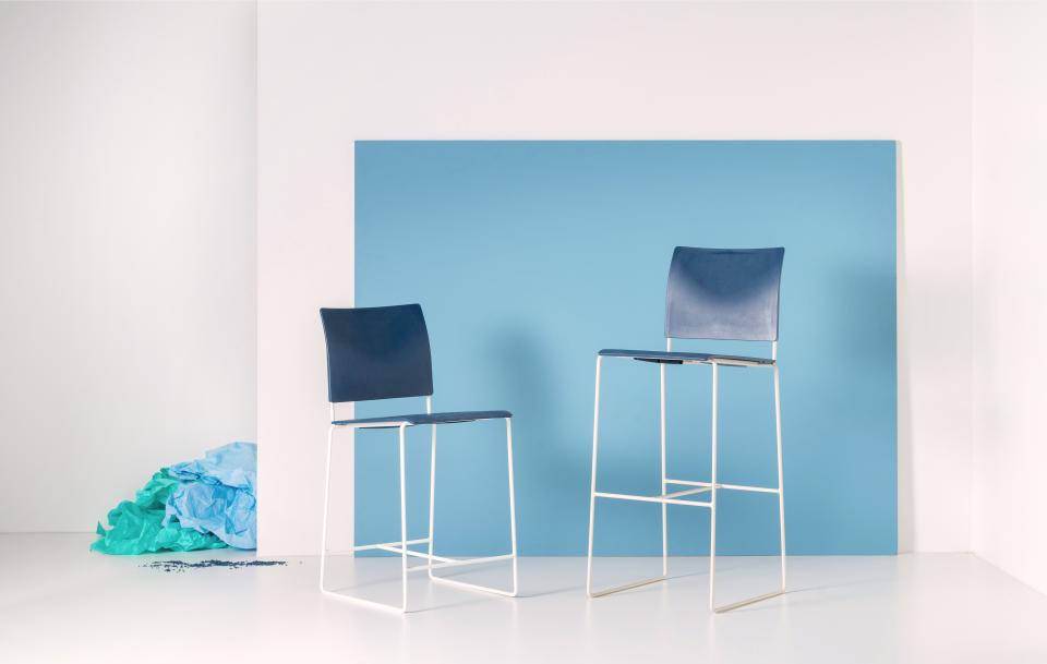 Sustainable blue Finn stools made from repurposed hospital waste, set against a light blue backdrop.