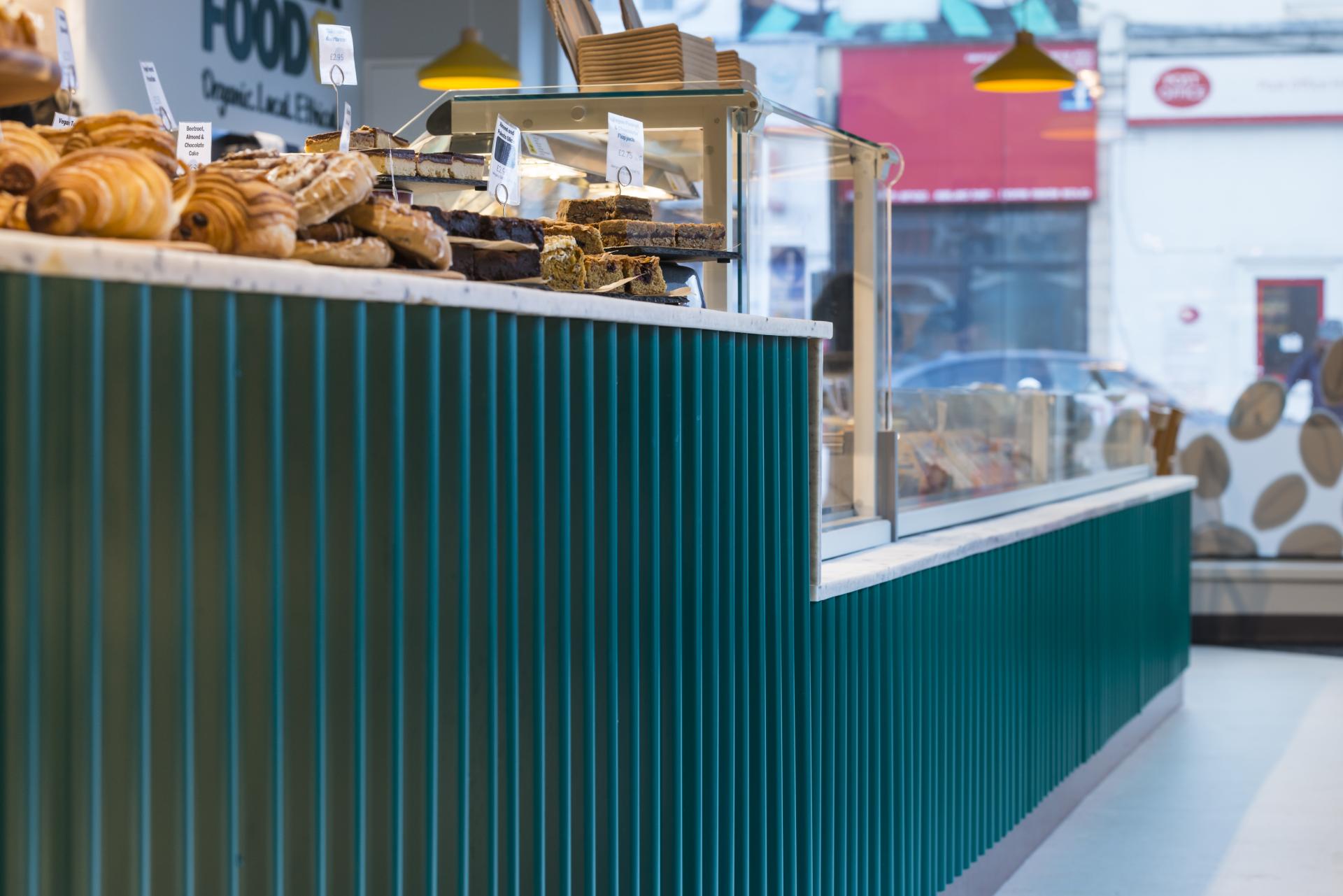 Display of freshly baked pastries and cakes at Better Food's new Gloucester Road store, designed by Phoenix Wharf.