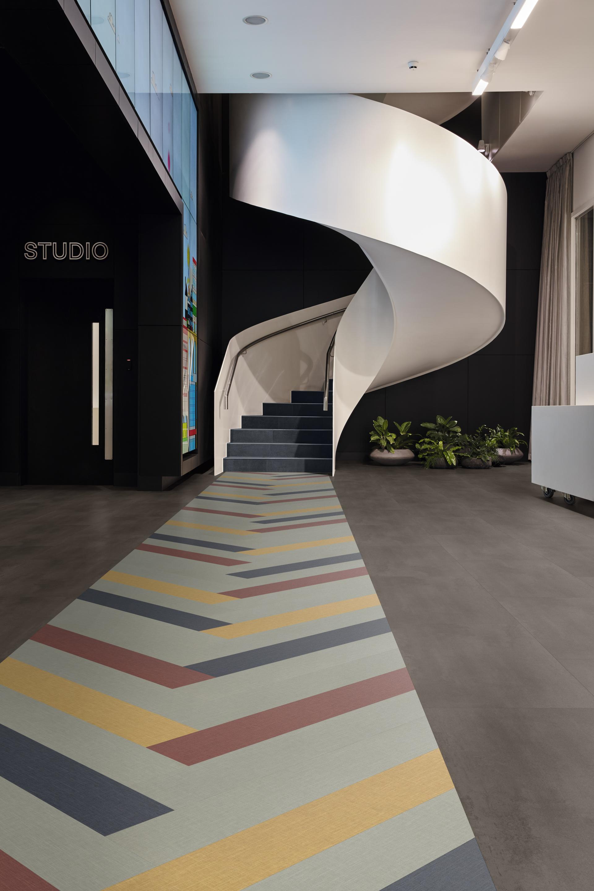 Stylish interior featuring Karndean's Opus abstract flooring design, showcasing colorful geometric patterns and a modern staircase.