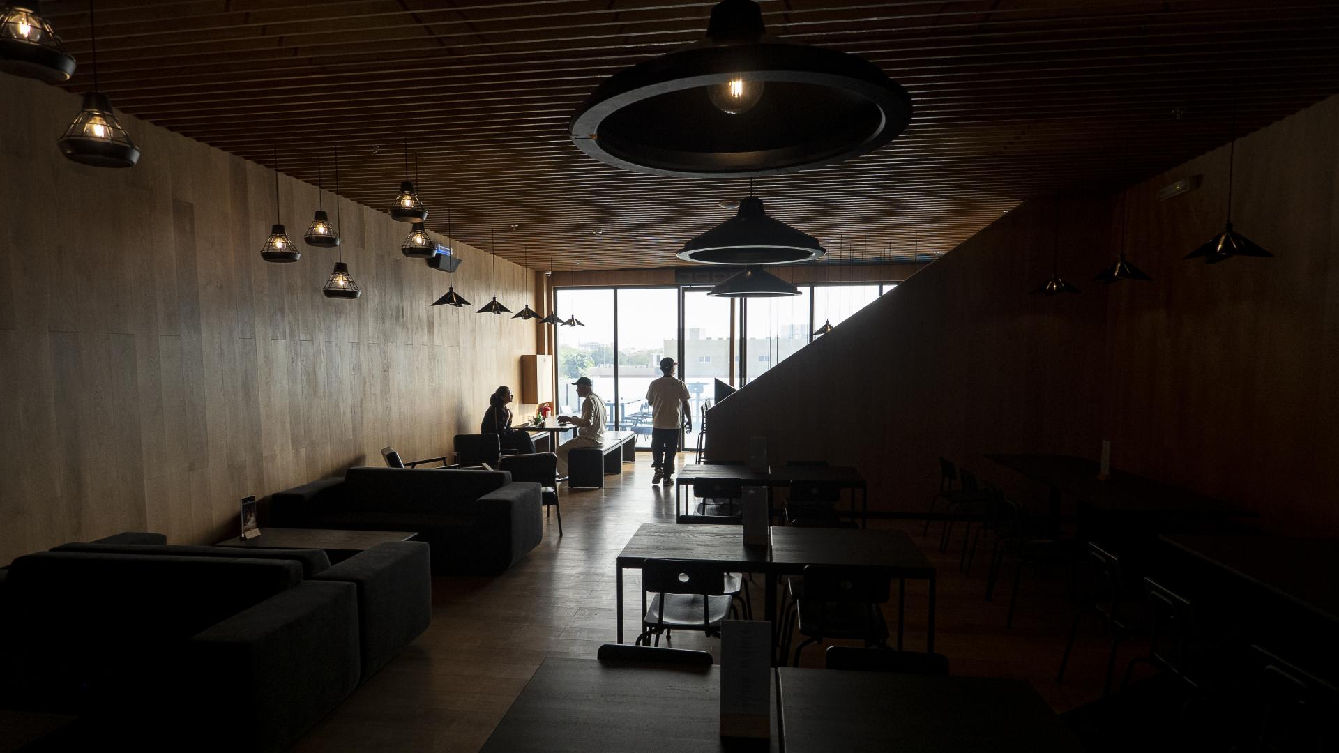 Modern coffee shop interior designed by Liqui Group, featuring cozy seating and large windows for natural light.