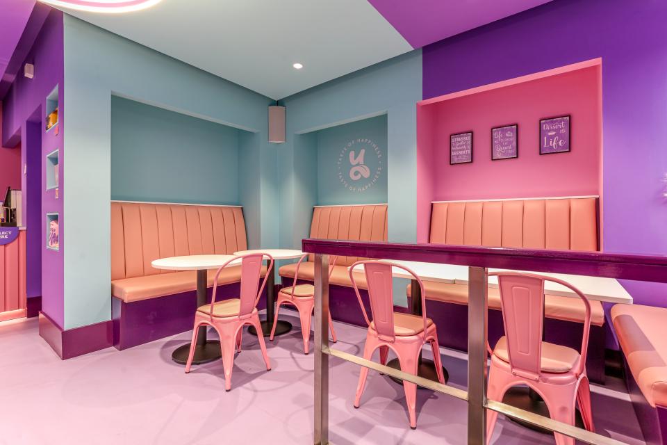 Vibrant seating area in a colorful dessert café designed by Phoenix Wharf, featuring pink and blue decor.