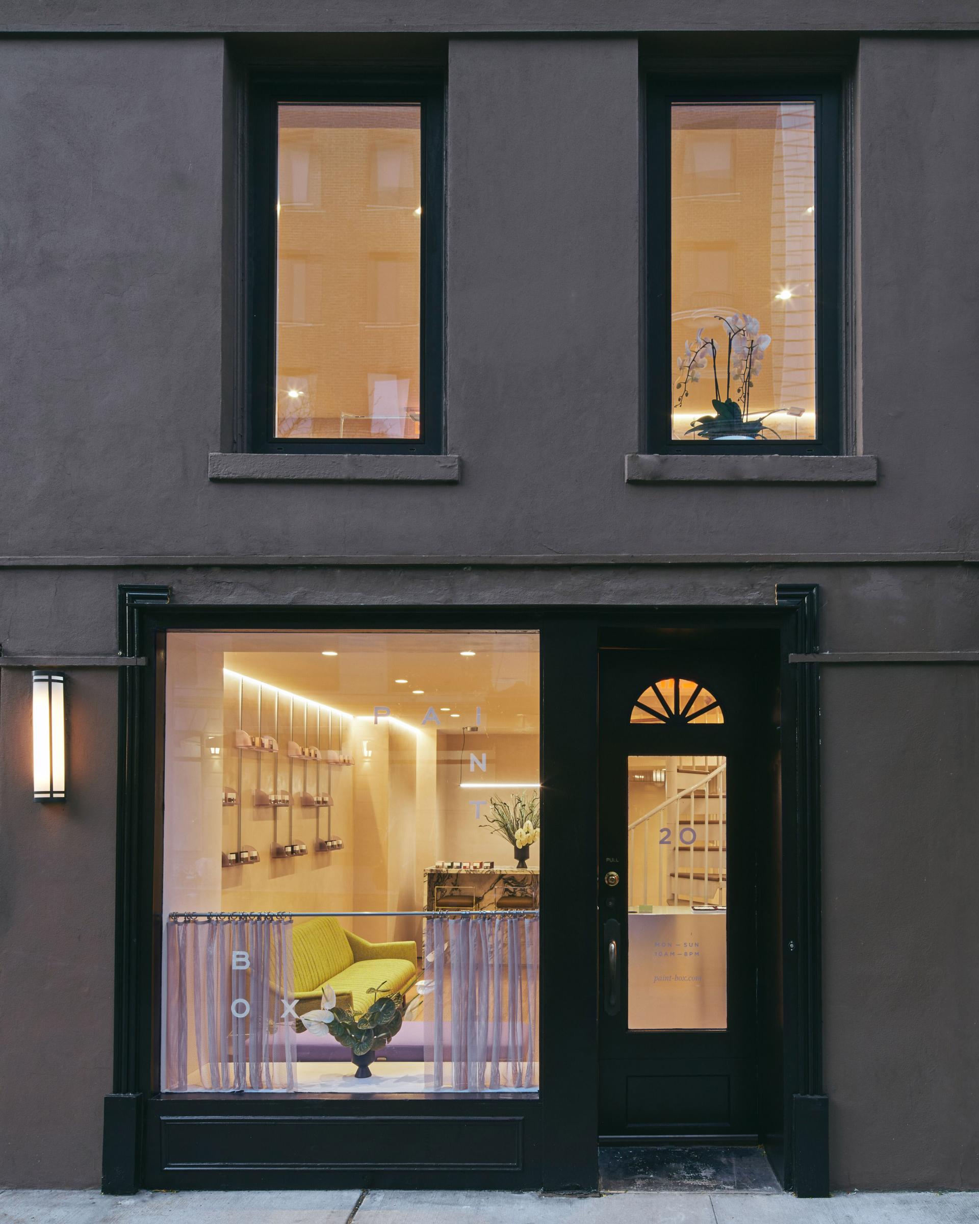 Exterior view of Paintbox nail studio in New York, featuring a contemporary design and vibrant yellow seating.