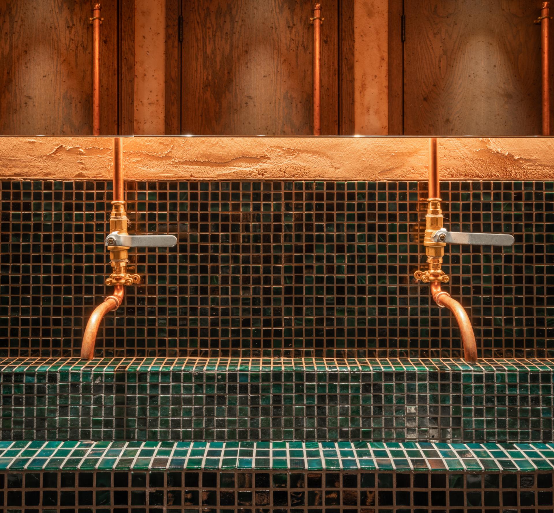 Stylish copper faucets above a green mosaic-tiled basin in Andrew Wong's new restaurant design by Michaelis Boyd.