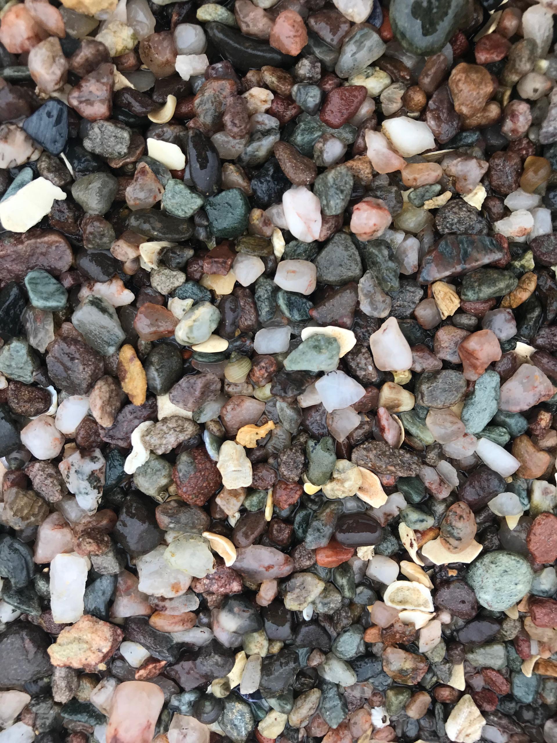 Colorful assortment of small stones and pebbles, showcasing textures and natural materials for David Irwin x Bute Fabrics collaboration.