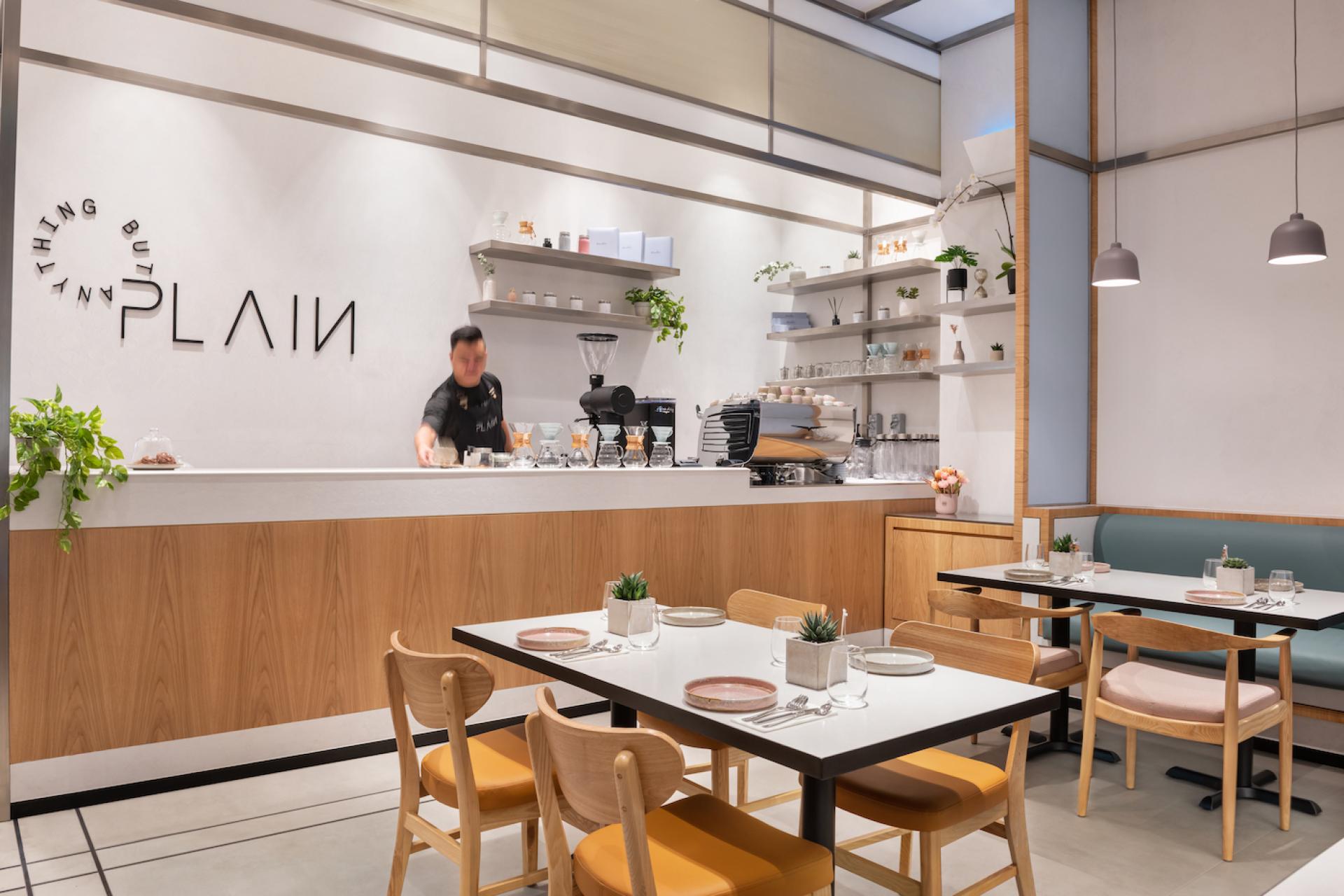 Modern dessert shop interior featuring sleek design, a barista preparing handcrafted treats, and stylish seating arrangements.