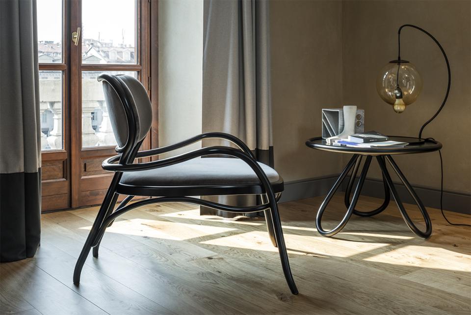 Elegant black chair and modern table showcasing contemporary design in a well-lit interior space.