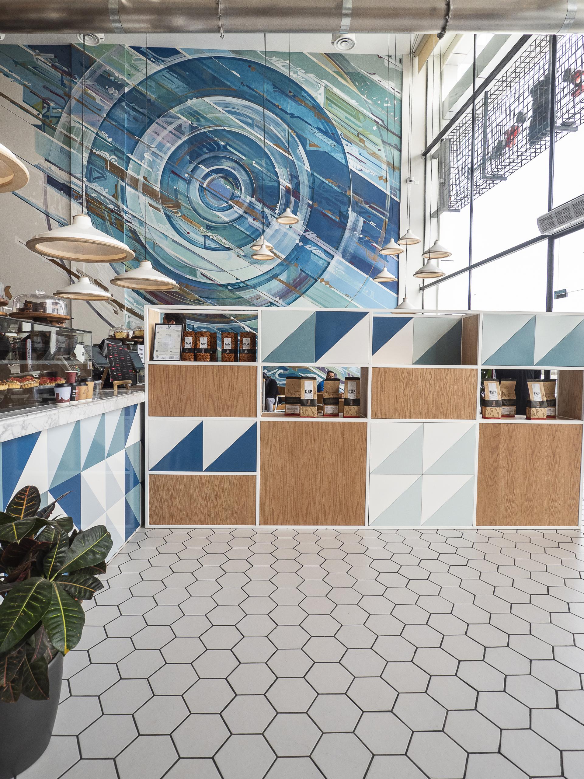Interior design of Brew92 café showcasing geometric patterns, a vibrant mural, and a modern, inviting atmosphere.
