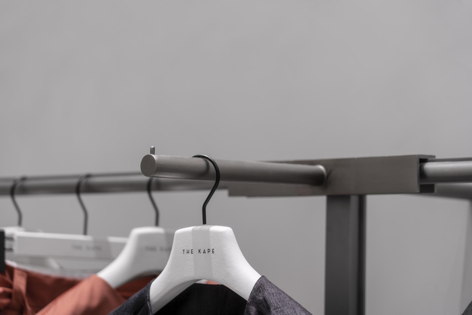 Stylish modest women's fashion garments displayed on hangers at THE KAPE boutique in Dubai.