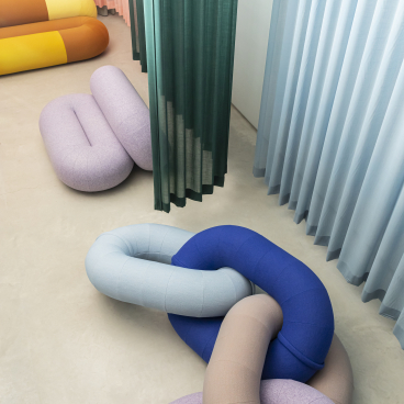 Colorful, sculptural textile forms in a minimalistic space, showcasing innovative design trends from the 2023 design event.