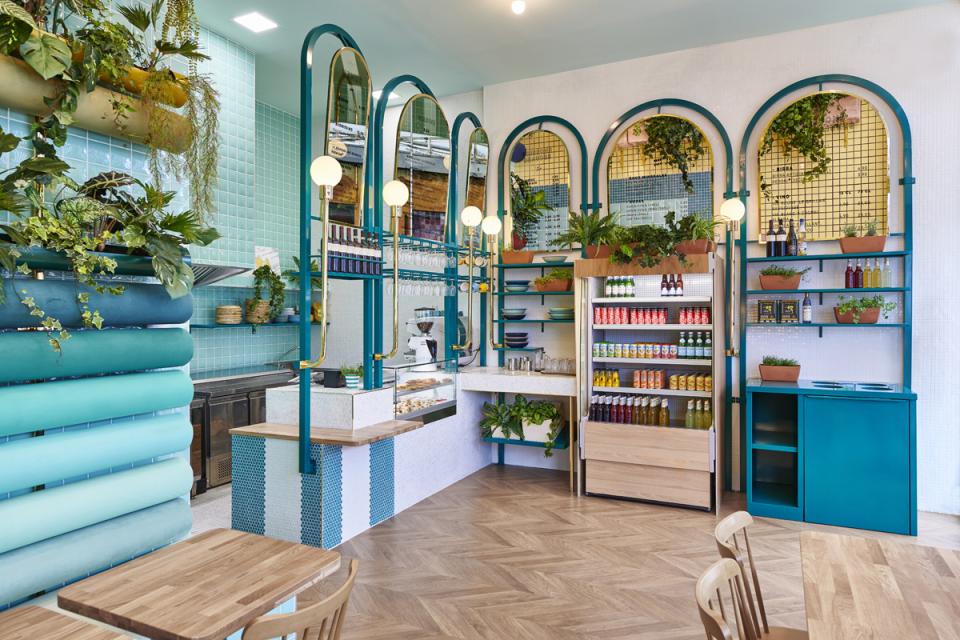 Contemporary interior design of Piada restaurant in Lyon featuring greenery, blue tones, and modern Italian aesthetics.