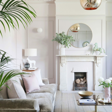 Stylish living room featuring a velvet sofa, decorative mirror, and modern elements, showcasing the design approach of 2LG Studio.