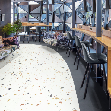 Contemporary workspace featuring Karndean's Opus abstract flooring, with stylish seating and striking geometric windows.