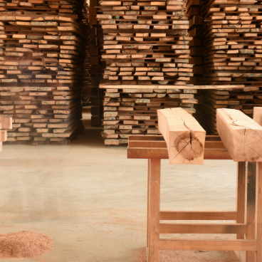 Stacks of sustainably sourced wood in a workshop, highlighting CRAFTWAND's commitment to quality and nature.