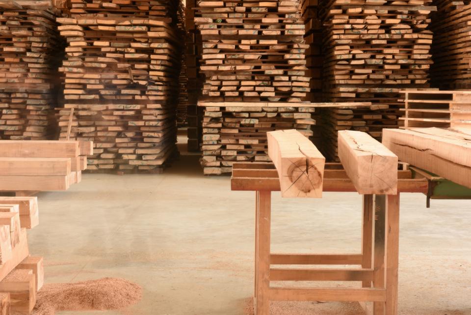 Stacks of sustainably sourced wood in a workshop, highlighting CRAFTWAND's commitment to quality and nature.