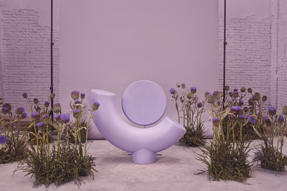 Colorful sculptural chair amidst vibrant flowers, representing the friendship-inspired 3 Characters collection by Masquespacio.