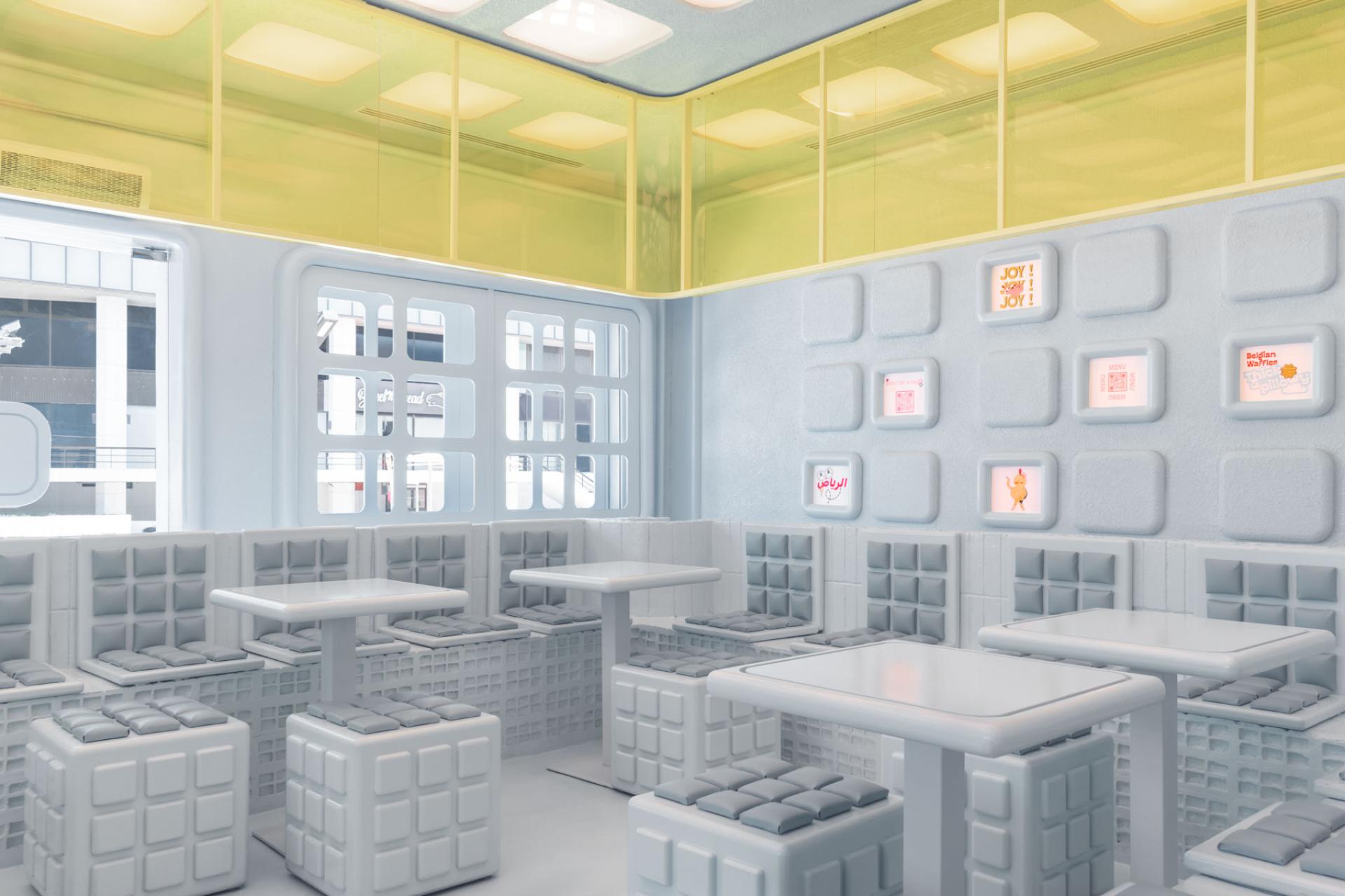 Futuristic interior of Novu Waffle featuring modular seating and colorful accents, designed by Masquespacio.