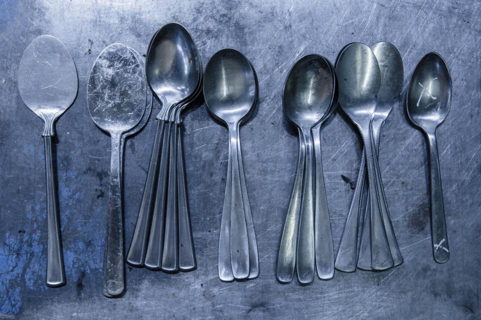 Assorted metal spoons displayed on a metallic surface, showcasing craftsmanship from Tsubame-Sanjo at Japan House London.