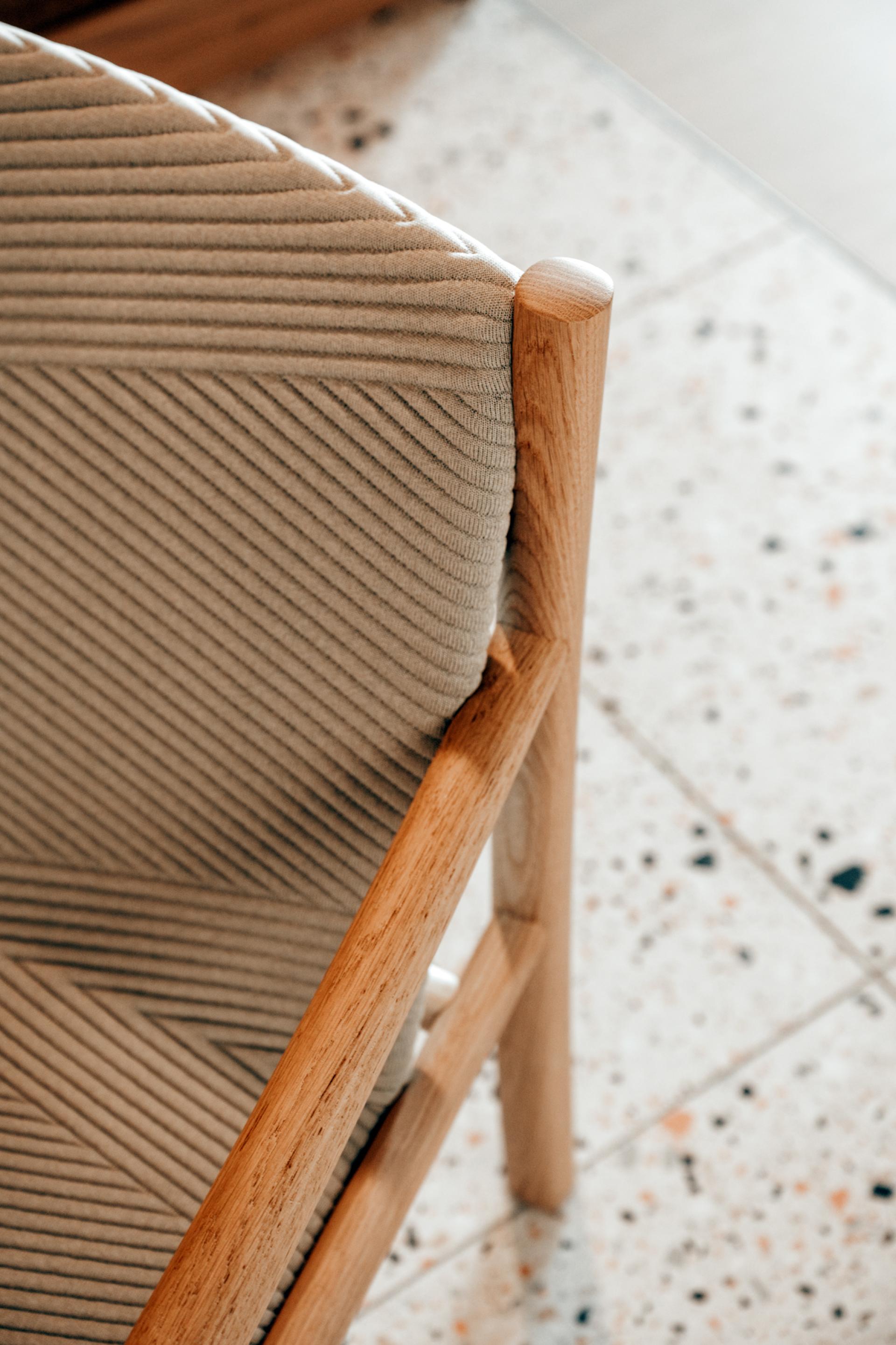 Stylish wooden chair with ribbed upholstery, highlighting Edinburgh's design elegance and craftsmanship in Dentons' new workspace.