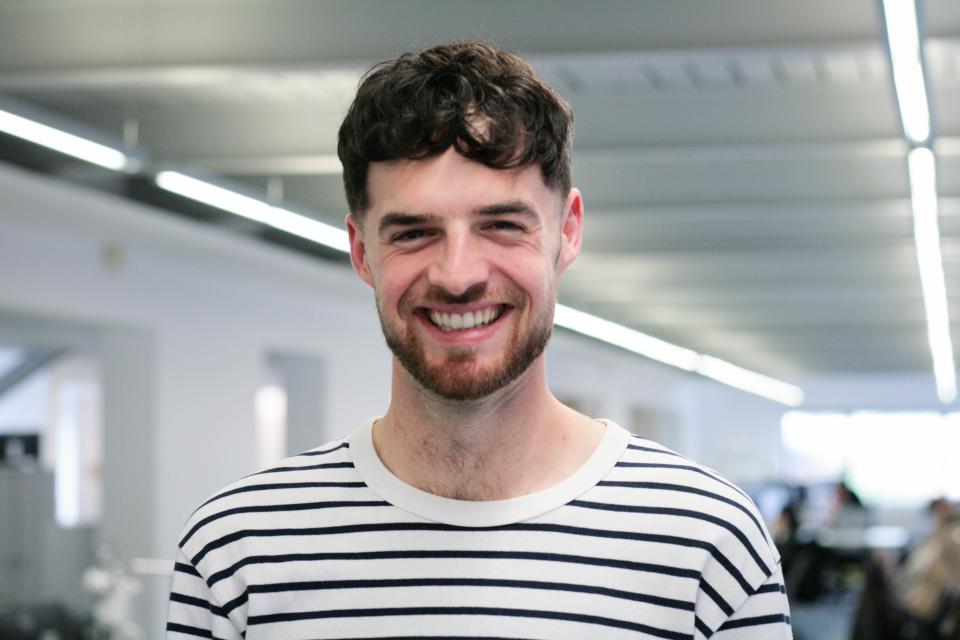 Liam Briggs from Buttress smiling in a modern office, discussing innovative project strategies and interview techniques.