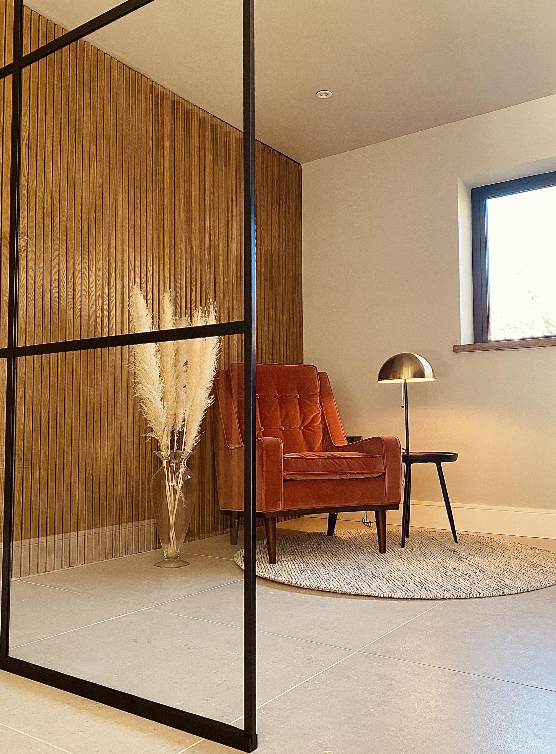 Stylish interior design featuring a cozy velvet armchair, modern lamp, and decorative pampas grass in a Manchester studio.