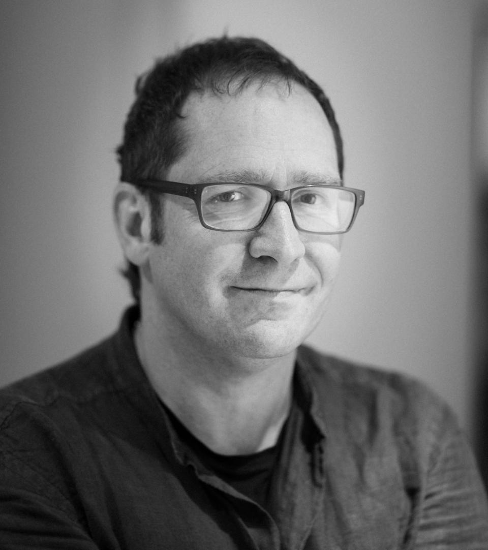 Patrick Thomas, founder of Up North Architects, smiling during an interview about architecture and design in Manchester.