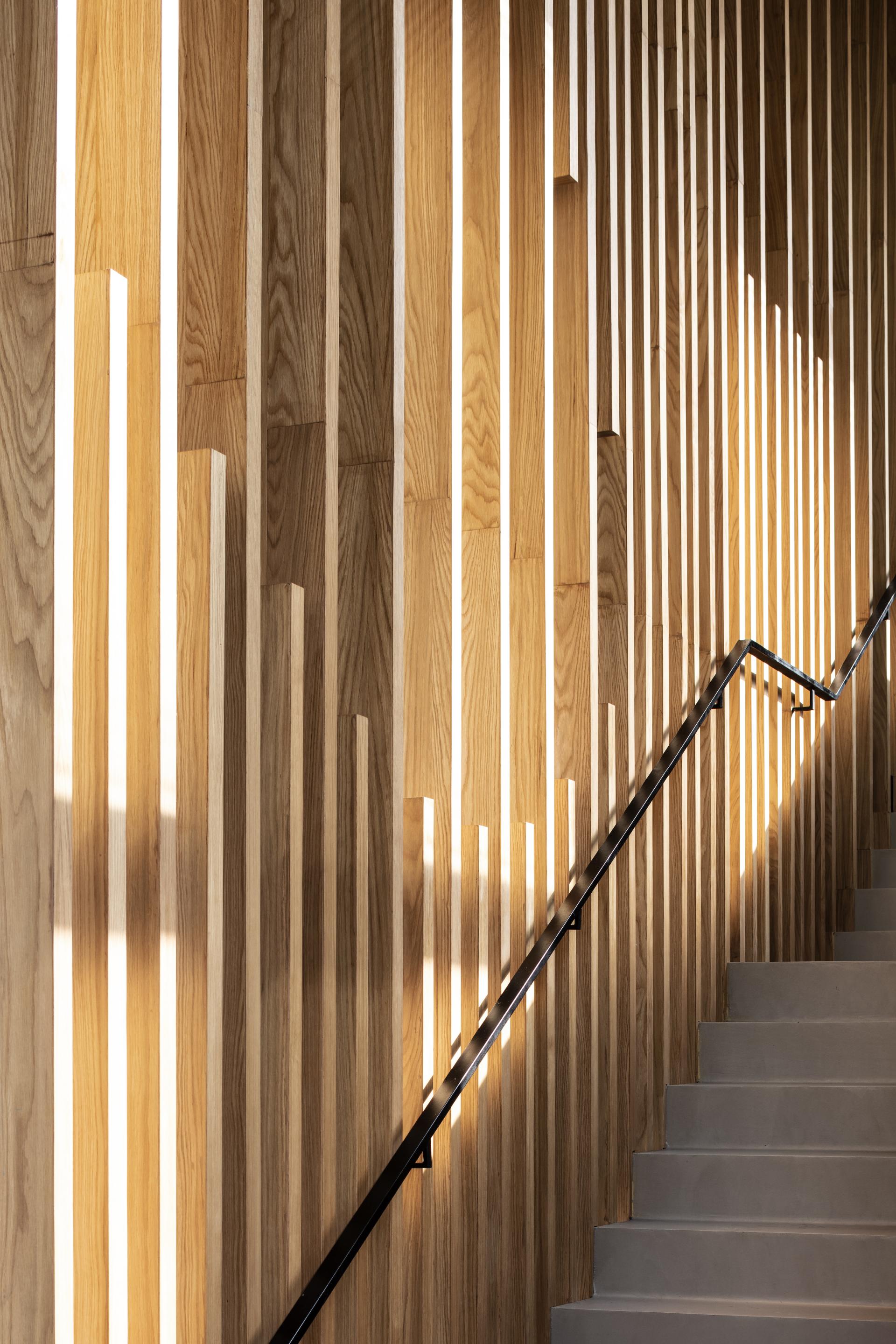 Suspended wooden slats create a striking backdrop along the staircase in this Tel Aviv restaurant designed by Kimmel Eshkolot Architects.
