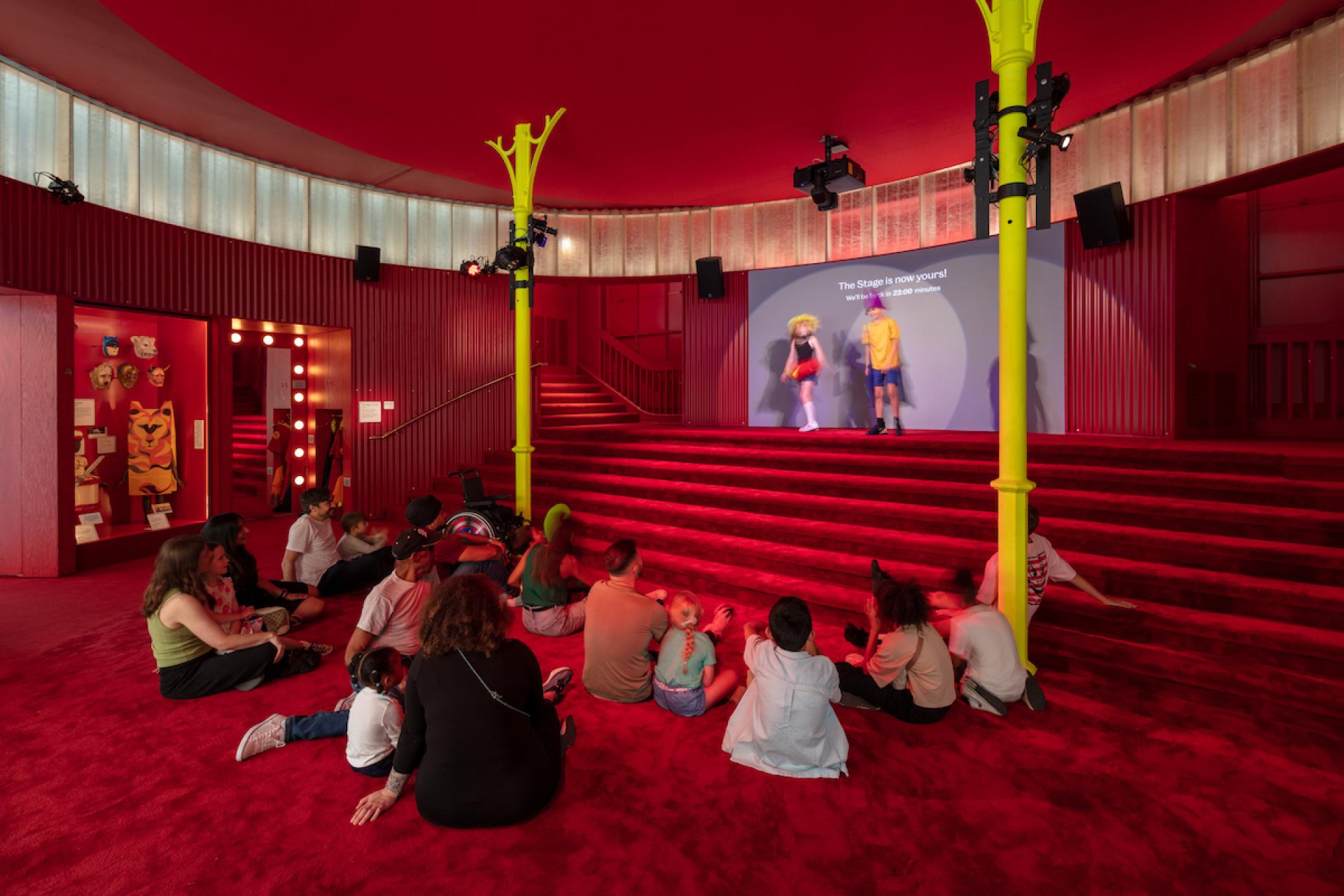 Children engage with a performance stage in a vibrant, inviting space at the Young V&A museum.