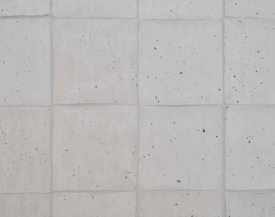 Textured white tiles with natural materials, showcasing Saint Charles' commitment to eco-friendly design in Salzburg store.