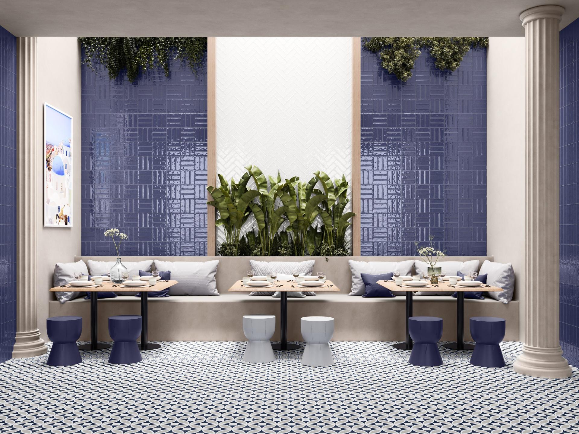 Stylish dining area featuring vibrant textured tiles, modern seating, and lush greenery, showcased at Surface Design Show 2023.
