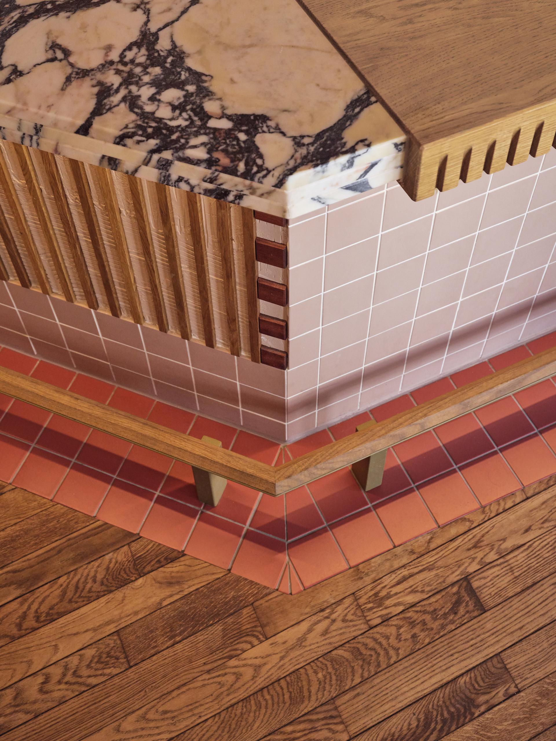 Stylish interior detail of Volare trattoria, featuring a marble countertop, wood accents, and colorful tiled flooring.