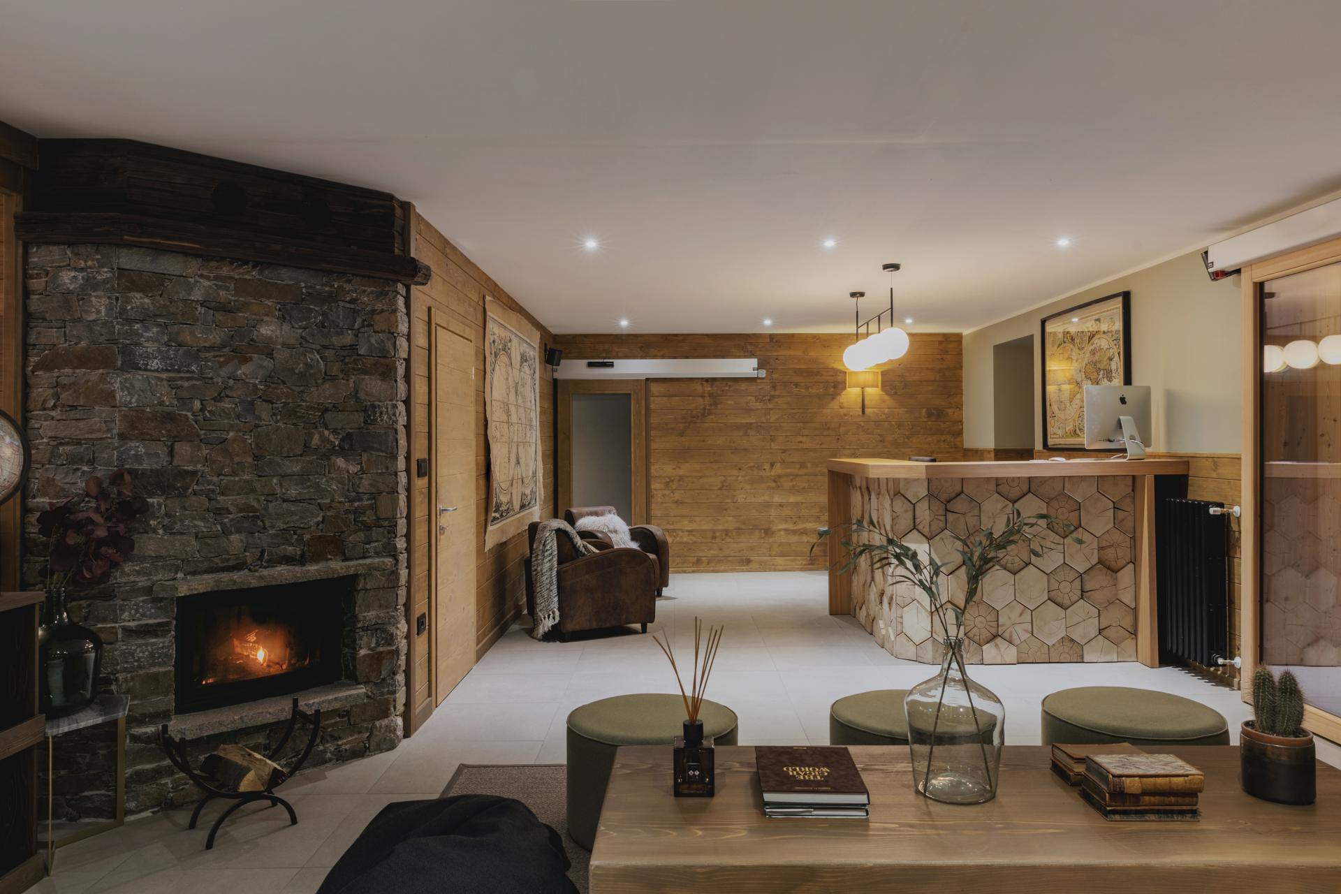 Modern reception area of a sustainably designed hotel, featuring natural materials, cozy furnishings, and a warm fireplace.