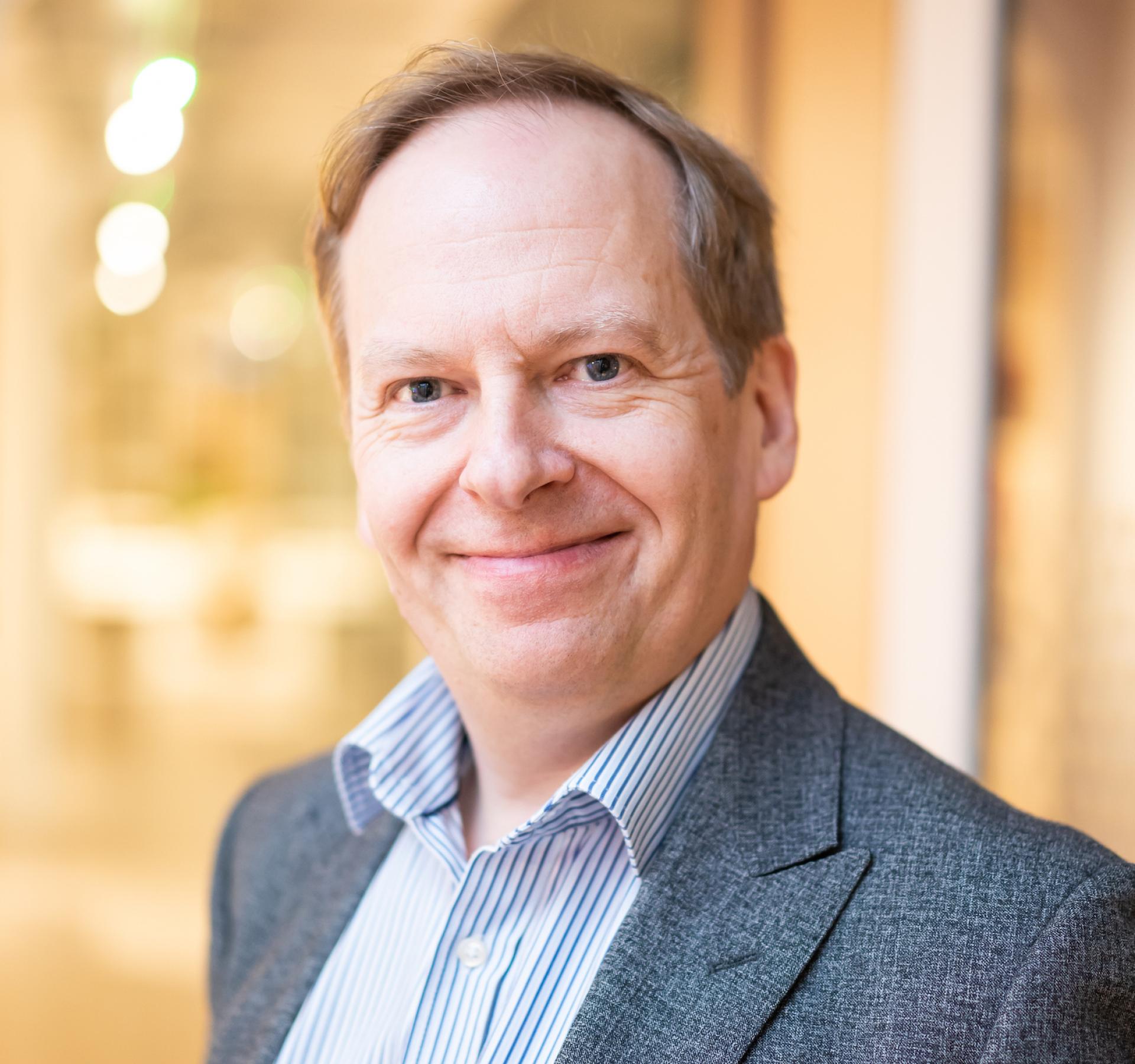 Professional man smiling in a modern educational setting, reflecting the future of innovative learning environments.