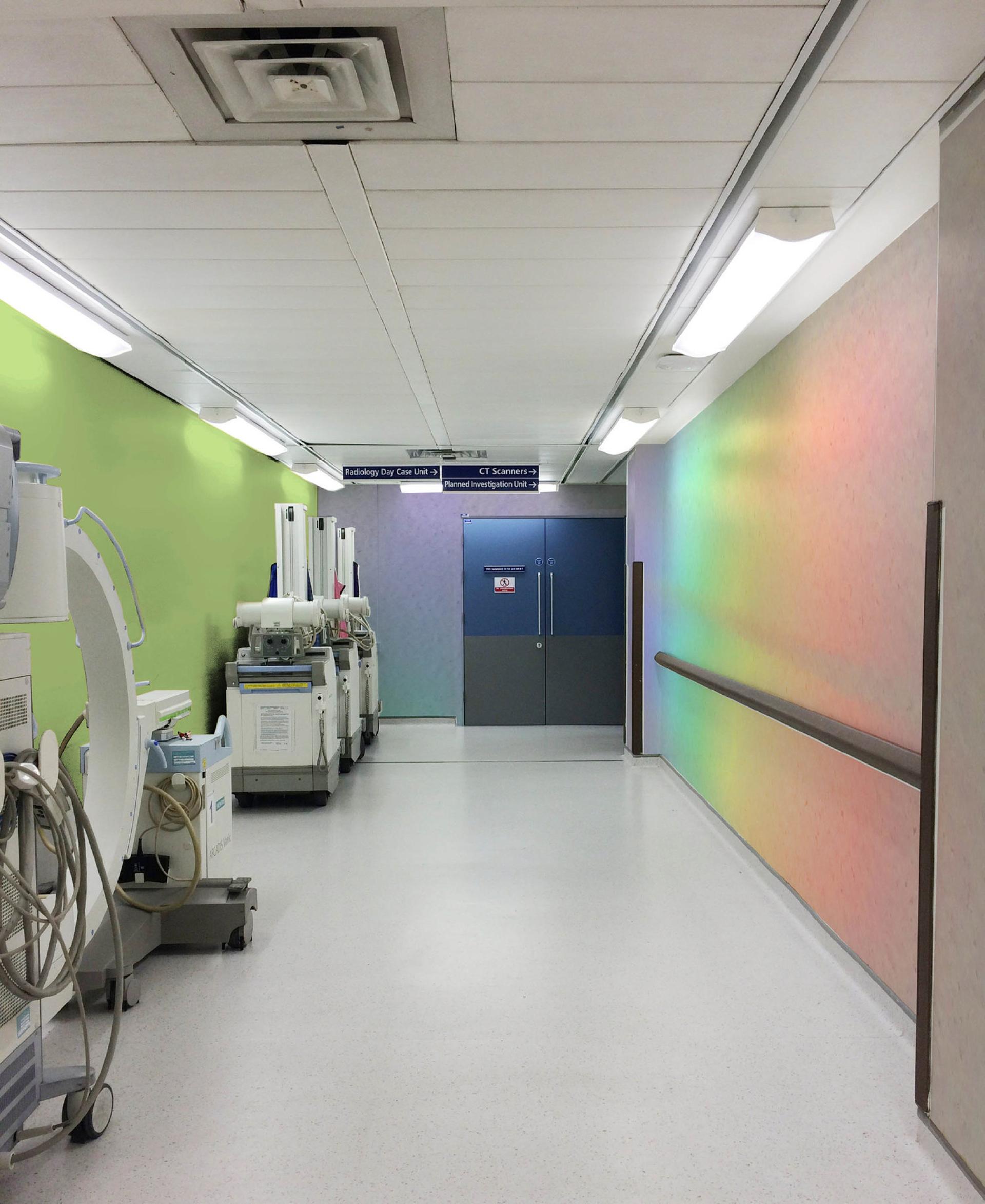 Colorful hospital corridor featuring medical equipment, with bright walls highlighting a modern healthcare environment.