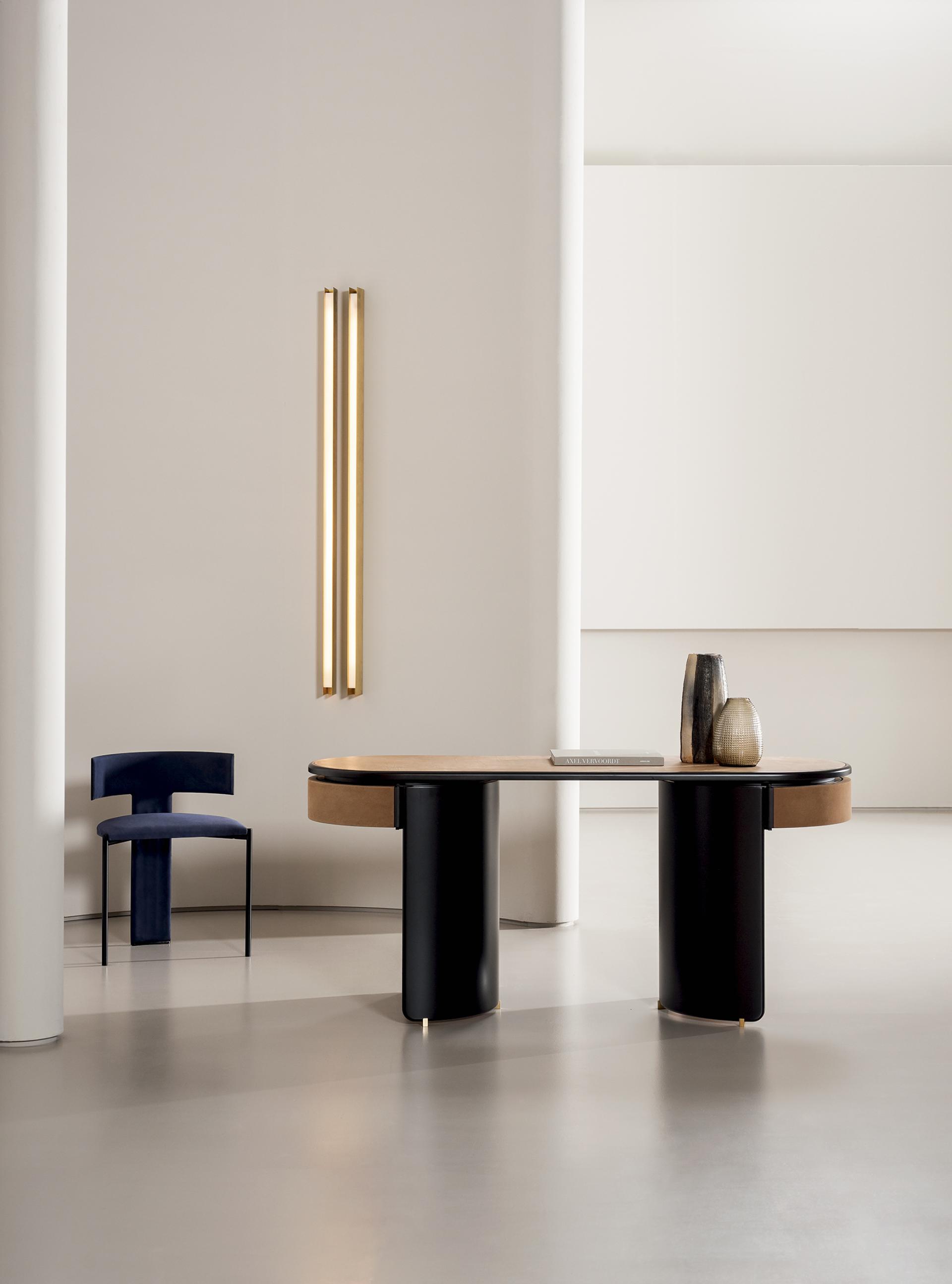 Contemporary luxury furniture display featuring a sleek table, elegant chair, and decorative vases at Baxter Worldwide 2020.